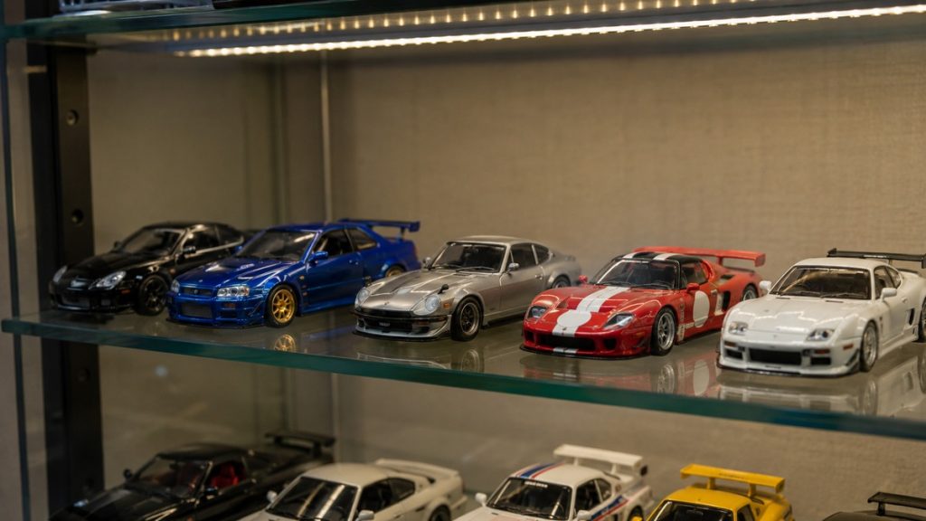 1:64 Modellautos in einer beleuchteten Sammlervitrine