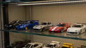 Mehrere Modellautos im Maßstab 1:64 nebeneinander in einer Sammlervitrine.